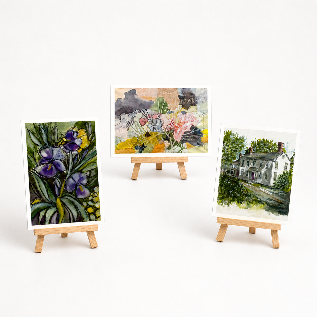 three prints by watercolor artist chuck delpapa on small easels, unframed